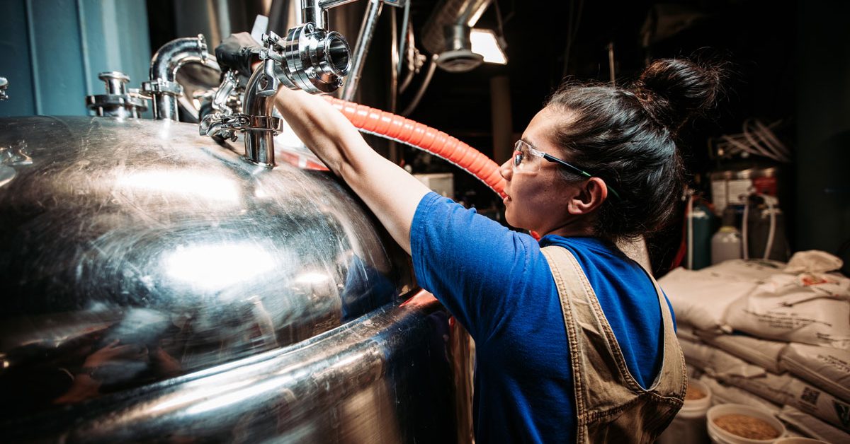 women working at bright tank back of house brewery